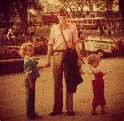 A childhood picture of Arwen Humphreys holding her father's hand